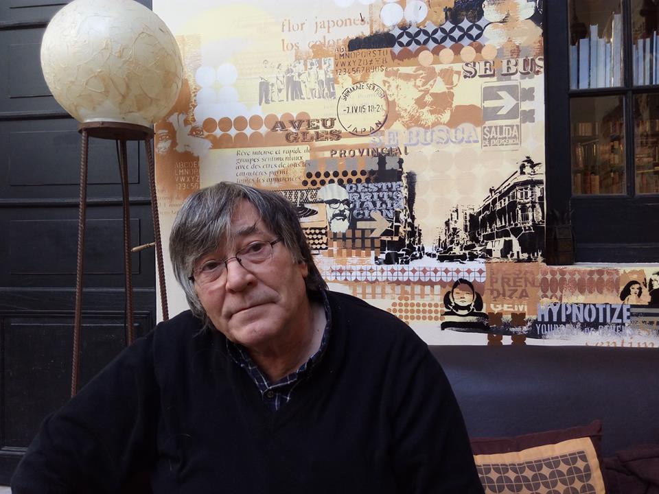 Jorge Panesi, un hombre de alrededor de 60 años, con el pelo grisáceo por las canas, mira a cámara con una expresión seria. De fondo tiene una pared decorada con estilo stencil.